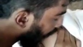 A man pleases his girlfriend by sucking on her large breasts