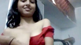 A seductive woman with large breasts records a striptease video for her partner, affectionately referred to as a bhabi