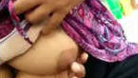 A South Asian woman teases her breasts and masturbates in a video showcasing fingering techniques